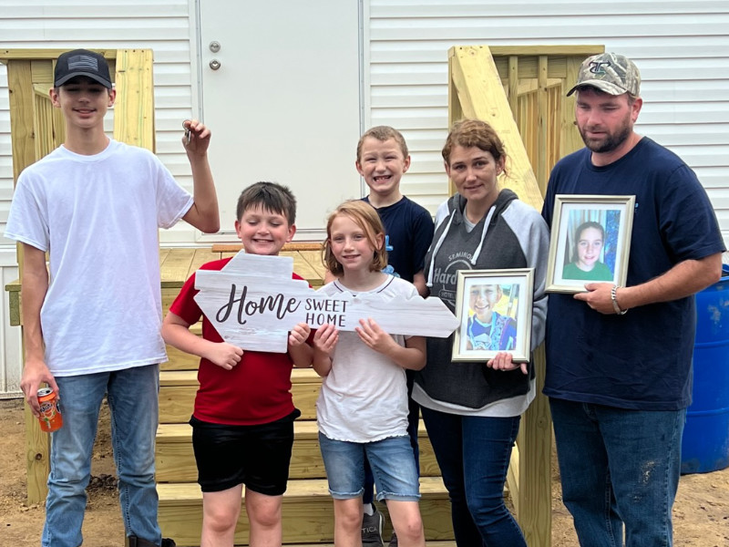 Young family standing in front of new home